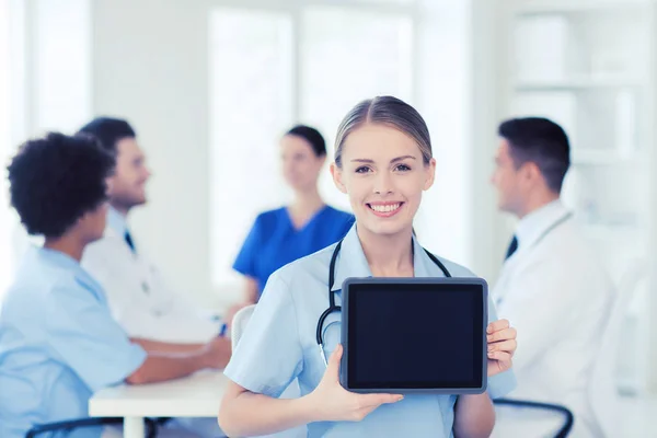 Zufriedener Arzt über Gruppe von Sanitätern im Krankenhaus — Stockfoto