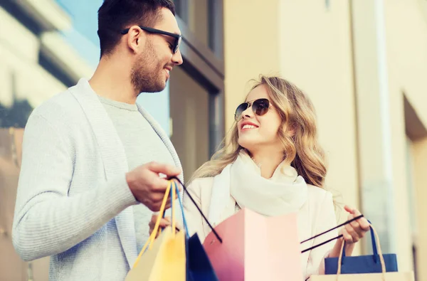 Happy couple with shopping bags on city street — Stock Photo, Image