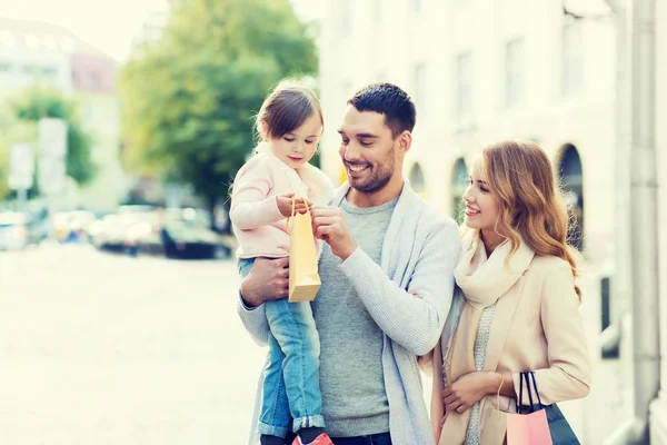 Lycklig familj med barn och shopping påsar i city — Stockfoto