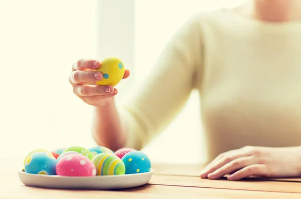 Close up de mãos de mulher com ovos de páscoa coloridos — Fotografia de Stock