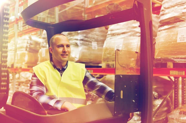 Glimlachende man die lader van de heftruck in het magazijn — Stockfoto