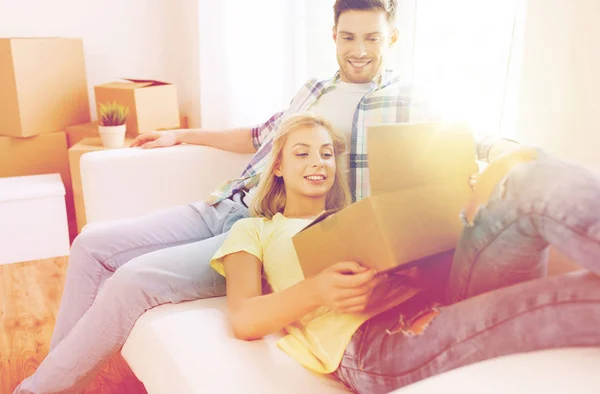Glückliches Paar mit großen Pappkartons im neuen Zuhause — Stockfoto