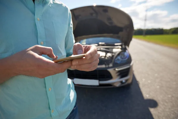 Close up of man with smartphone and broken car — Stock Photo, Image