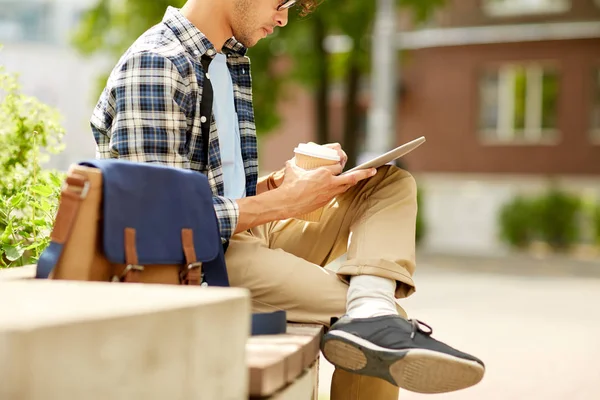 Man with tablet pc and coffee on city street bench — Stock Photo, Image