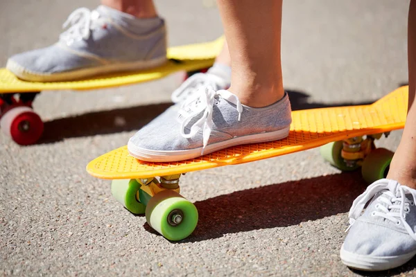 Primer plano de pies femeninos montar monopatín corto — Foto de Stock