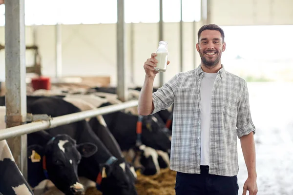 Homem ou agricultor com leite de vaca na exploração leiteira — Fotografia de Stock