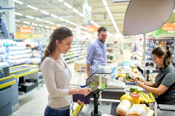 Couple buying food at grocery store cash register — Stock Photo, Image