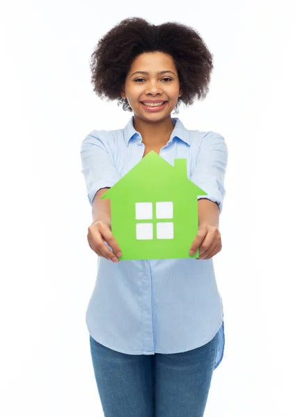 Happy african american woman with green house icon — Stock Photo, Image
