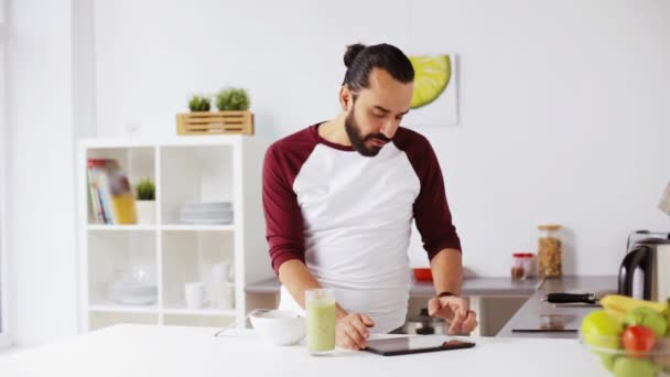 Чоловік з планшетним ПК їсть сніданок вдома — стокове відео