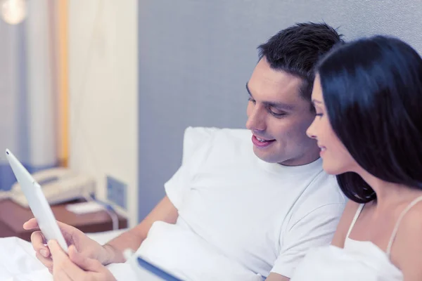 Smiling couple in bed with tablet pc computers — Stock Photo, Image