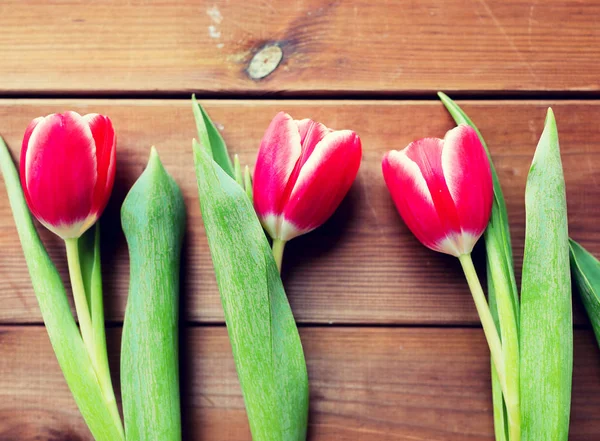 Gros plan de fleurs de tulipes rouges sur une table en bois — Photo