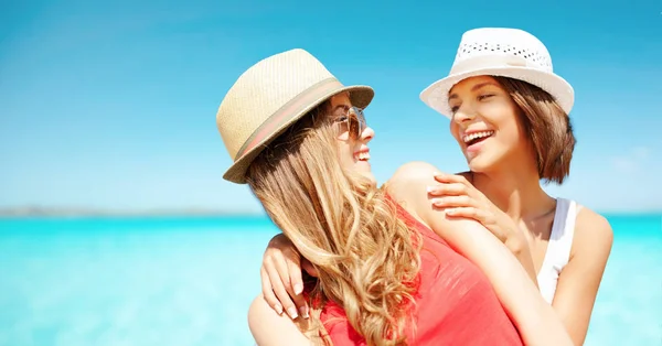 Ευτυχισμένος νεαρές γυναίκες σε καπέλα στην παραλία το καλοκαίρι — Φωτογραφία Αρχείου