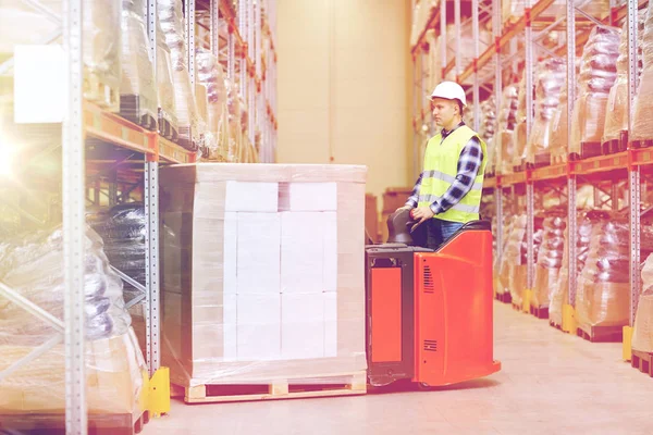Homem em caixas de carregamento de empilhadeira no armazém — Fotografia de Stock