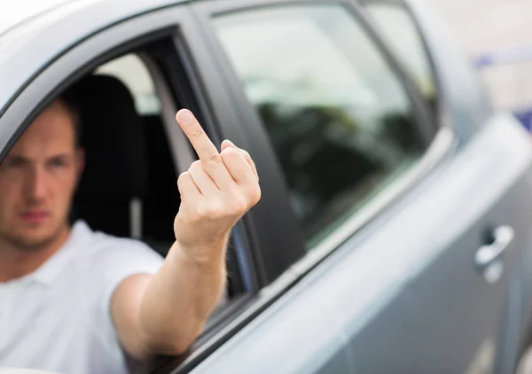 Κοντινό πλάνο του άνδρα οδήγηση αυτοκινήτου που δείχνει το μεσαίο δάχτυλο — Φωτογραφία Αρχείου