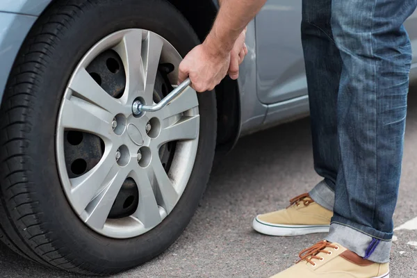 Nahaufnahme von Mann mit Schraubenschlüssel beim Reifenwechsel — Stockfoto