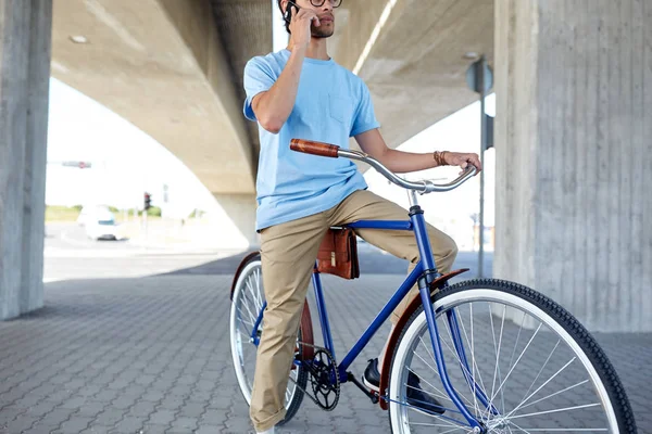 Hombre con teléfono inteligente y bicicleta de engranaje fijo en la calle — Foto de Stock