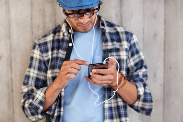 Человек с наушниками и смартфоном слушает музыку — стоковое фото