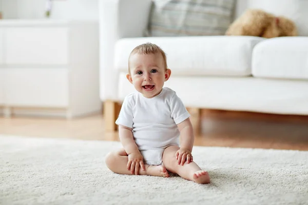 Gelukkig baby jongen of meisje zitten op de vloer thuis — Stockfoto