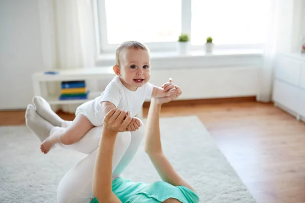 Gelukkig moeder spelen met baby thuis — Stockfoto