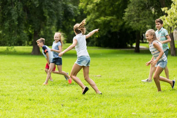 Ομάδα ευτυχής παιδιά ή τους φίλους που παίζουν σε εξωτερικούς χώρους — Φωτογραφία Αρχείου