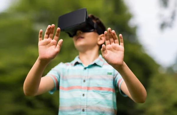 Niño con auriculares de realidad virtual al aire libre — Foto de Stock