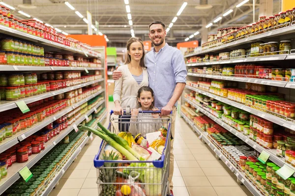 Familia con comida en el carrito de la compra en la tienda de comestibles —  Fotos de Stock