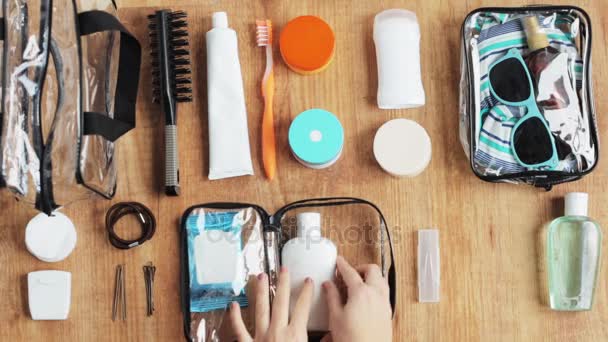 Manos embalaje bolsa de cosméticos con cosas para viajar — Vídeo de stock