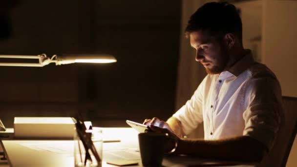 Человек с планшетным компьютером, работающий поздней ночью в офисе — стоковое видео