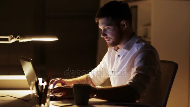 Homem com laptop trabalho de acabamento no escritório da noite — Vídeo de Stock