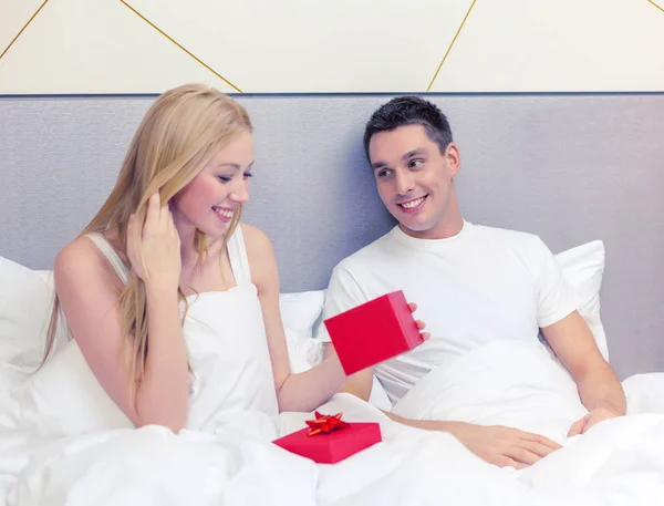 Hombre dando mujer pequeña caja de regalo roja — Foto de Stock