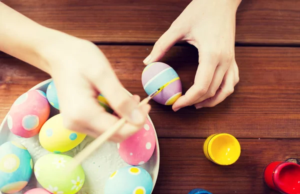 Close up of woman hands coloring easter eggs — Stock Photo, Image