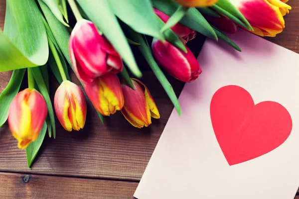 Close up of flowers and greeting card with heart — Stock Photo, Image