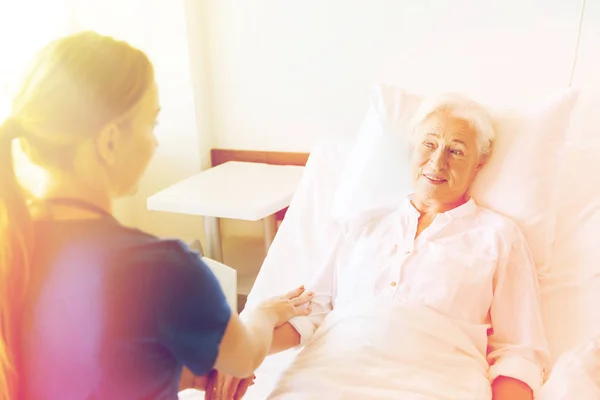 Médico o enfermero que visita a una mujer mayor en el hospital —  Fotos de Stock