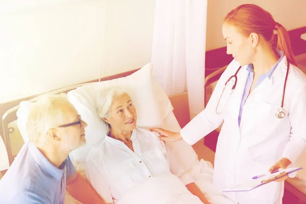 Mujer mayor y médico con portapapeles en el hospital —  Fotos de Stock