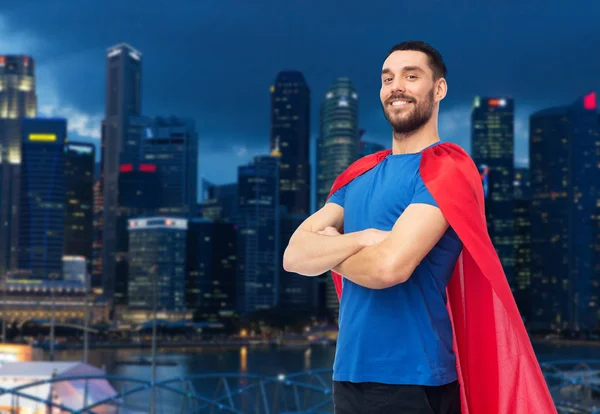 Hombre feliz en capa de superhéroe rojo durante la noche de la ciudad —  Fotos de Stock