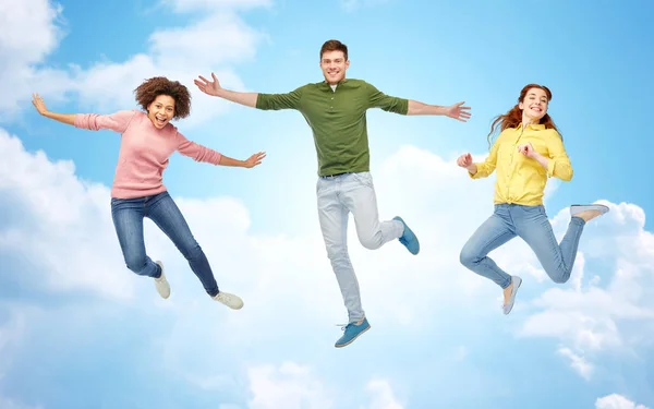 Smiling young man jumping in air — Stock Photo, Image