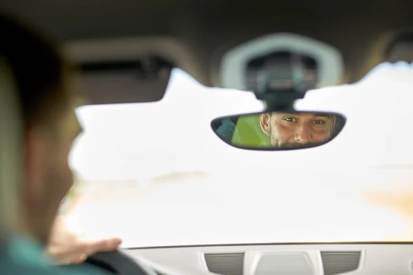 Espejo retrovisor reflejo del hombre conduciendo coche — Foto de Stock