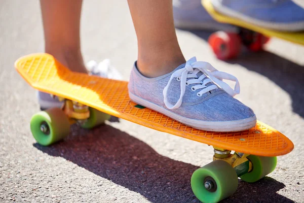 Primer plano de pies femeninos montar monopatín corto — Foto de Stock