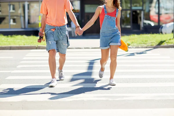 Pareja adolescente con patinetas en la ciudad crosswalk —  Fotos de Stock