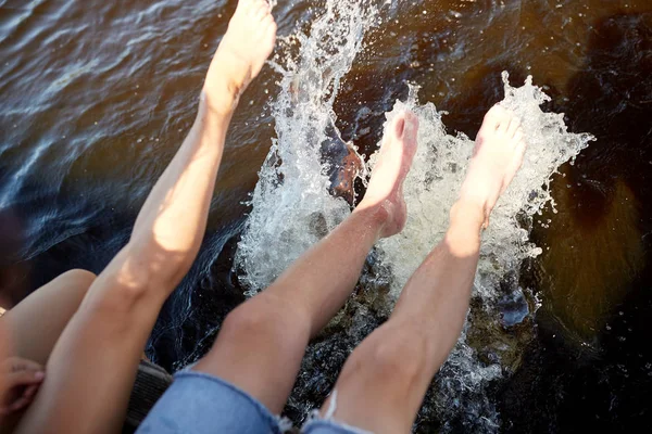 Legs of couple splashing water in river — Stock Photo, Image