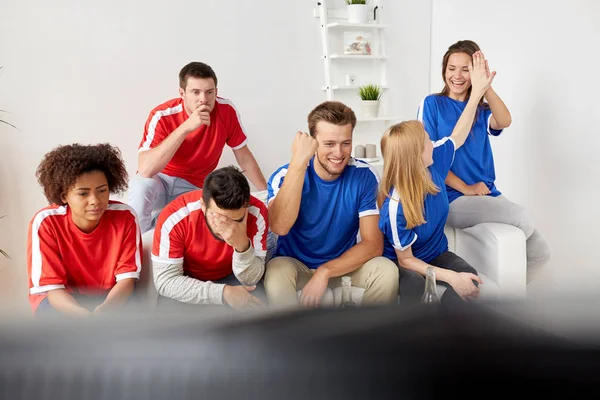 friends or football fans watching soccer at home