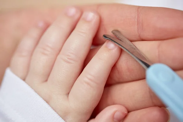 Zbliżenie dłoni nożyczkami, uporządkowanie paznokcie dziecka — Zdjęcie stockowe