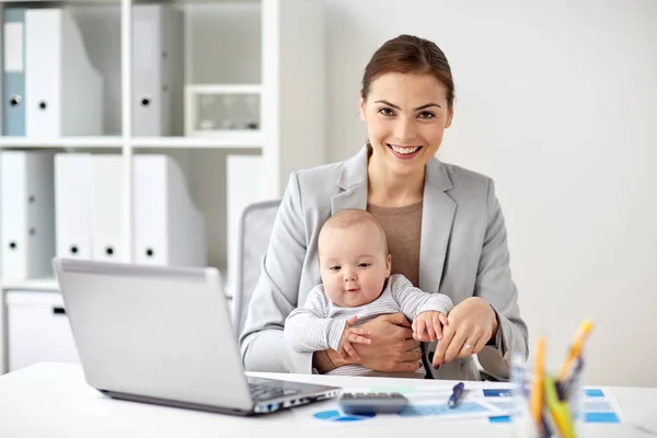 Feliz mujer de negocios con bebé y portátil en la oficina —  Fotos de Stock