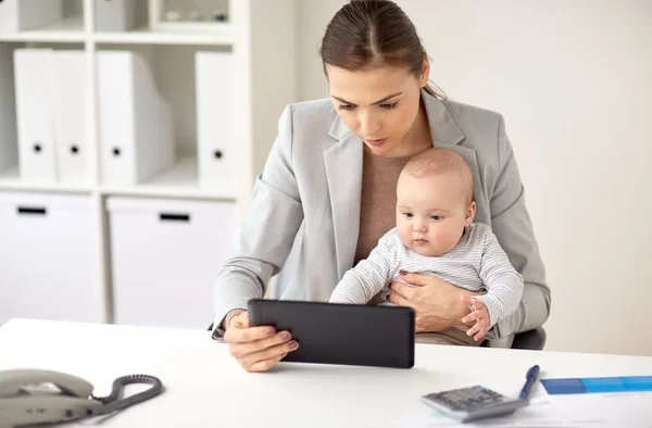 Zakenvrouw met baby en tablet pc op kantoor — Stockfoto