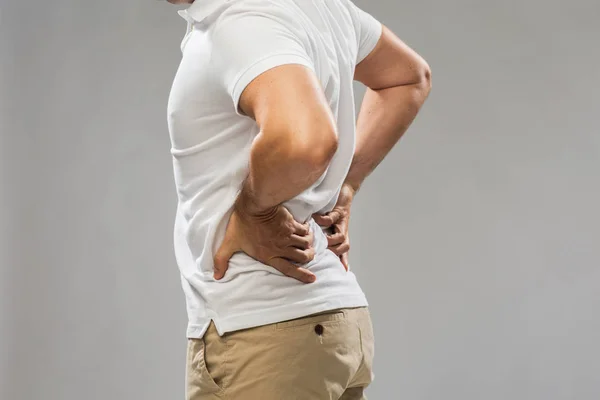 Lähikuva mies kärsii selkäkipu — kuvapankkivalokuva