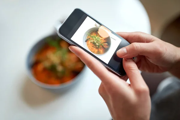Kobieta z smartphone fotografowania żywności w kawiarni — Zdjęcie stockowe