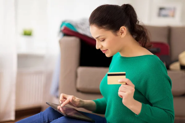 Mujer con tablet PC y tarjeta de crédito en casa — Foto de Stock