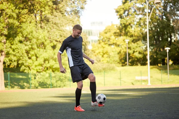 Jugador de fútbol jugando con pelota en el campo —  Fotos de Stock