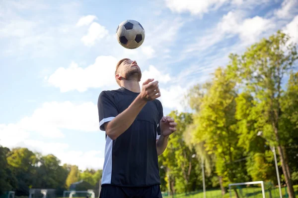 Fotbalový hráč hraje s míčem na hřišti — Stock fotografie