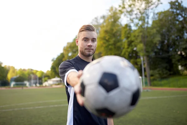 Футболист с мячом на футбольном поле — стоковое фото